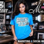 Mara bennett wearing a wrestlingtees. Net shirt in a wrestling office with championship belts and pro wrestling memorabilia