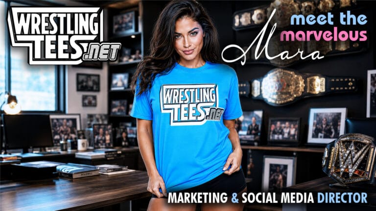 Mara Bennett wearing a WrestlingTees.net shirt in a wrestling office with championship belts and pro wrestling memorabilia